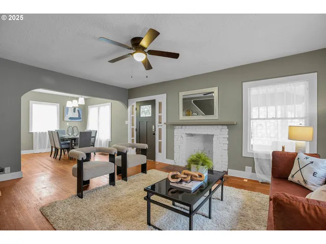 a living room with furniture a fireplace and a large window