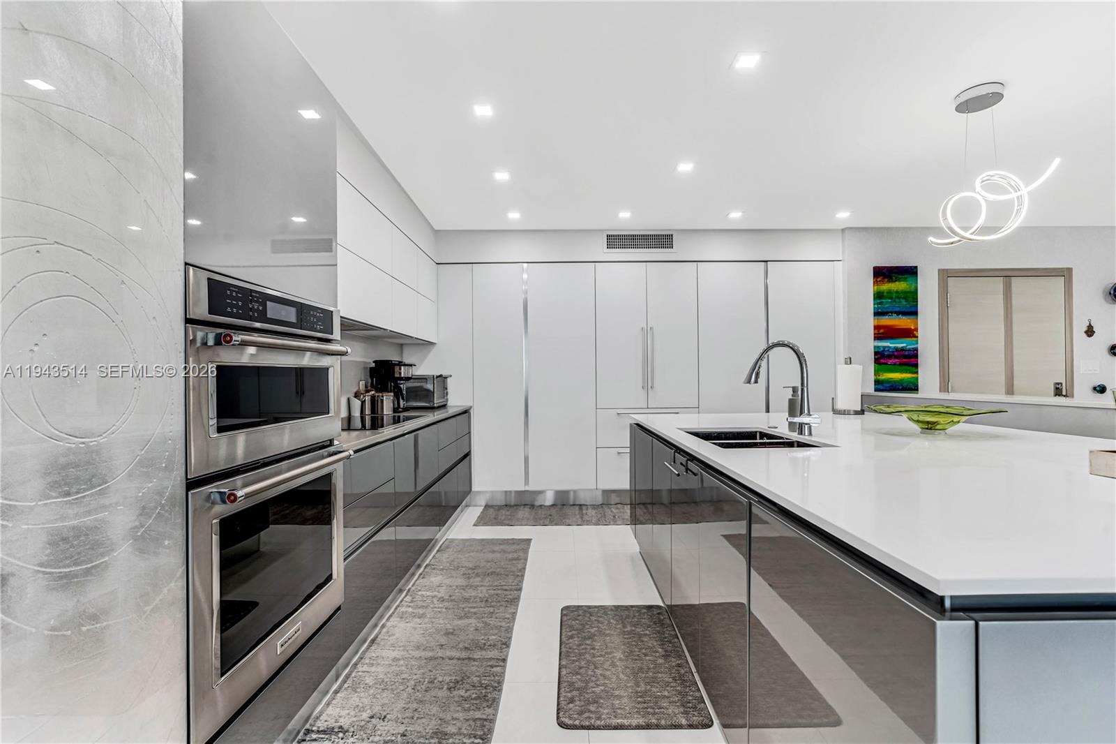 10155 Collins Avenue, Unit 606 Bal Harbour, FL 33154 - Photo 11 of 48 a kitchen with stainless steel appliances kitchen island granite countertop a stove and a sink