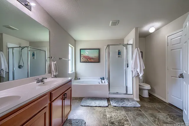 a bathroom with a double vanity sink toilet and shower