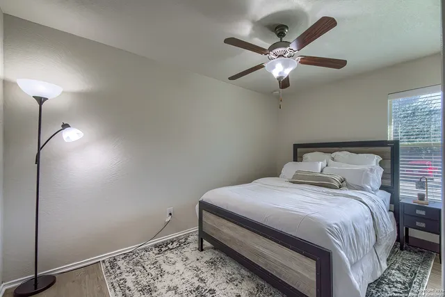a bedroom with a bed and ceiling fan