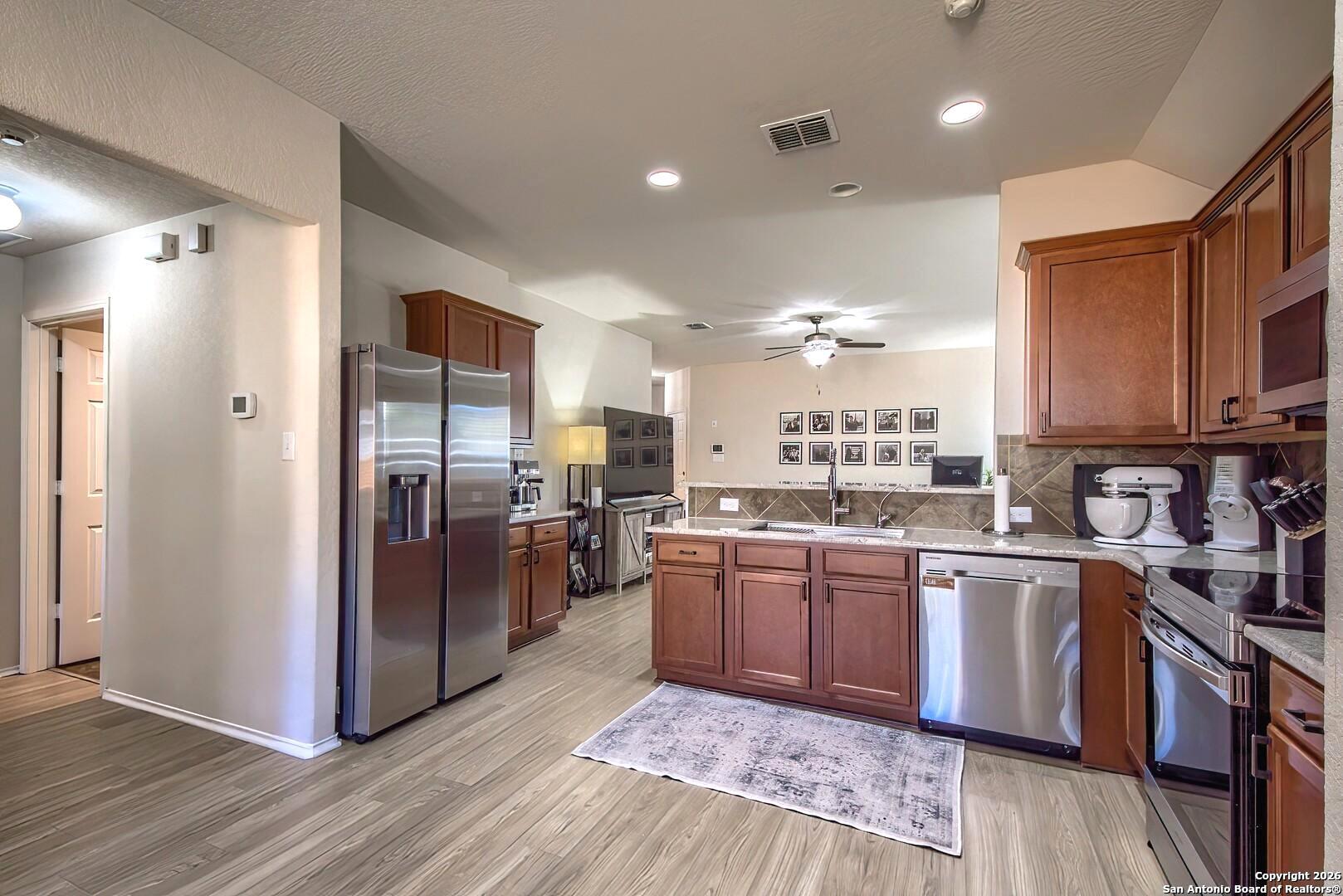 200 Stetson Street Cibolo, TX 78108 - Photo 3 of 28 a kitchen with stainless steel appliances granite countertop a refrigerator and a stove top oven