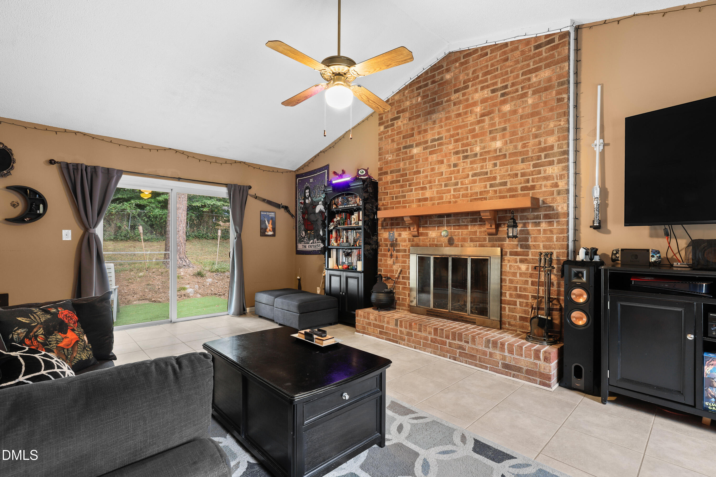 7412 Post Oak Road Raleigh, NC 27615 - Photo 3 of 27 a living room with furniture a flat screen tv and a fireplace
