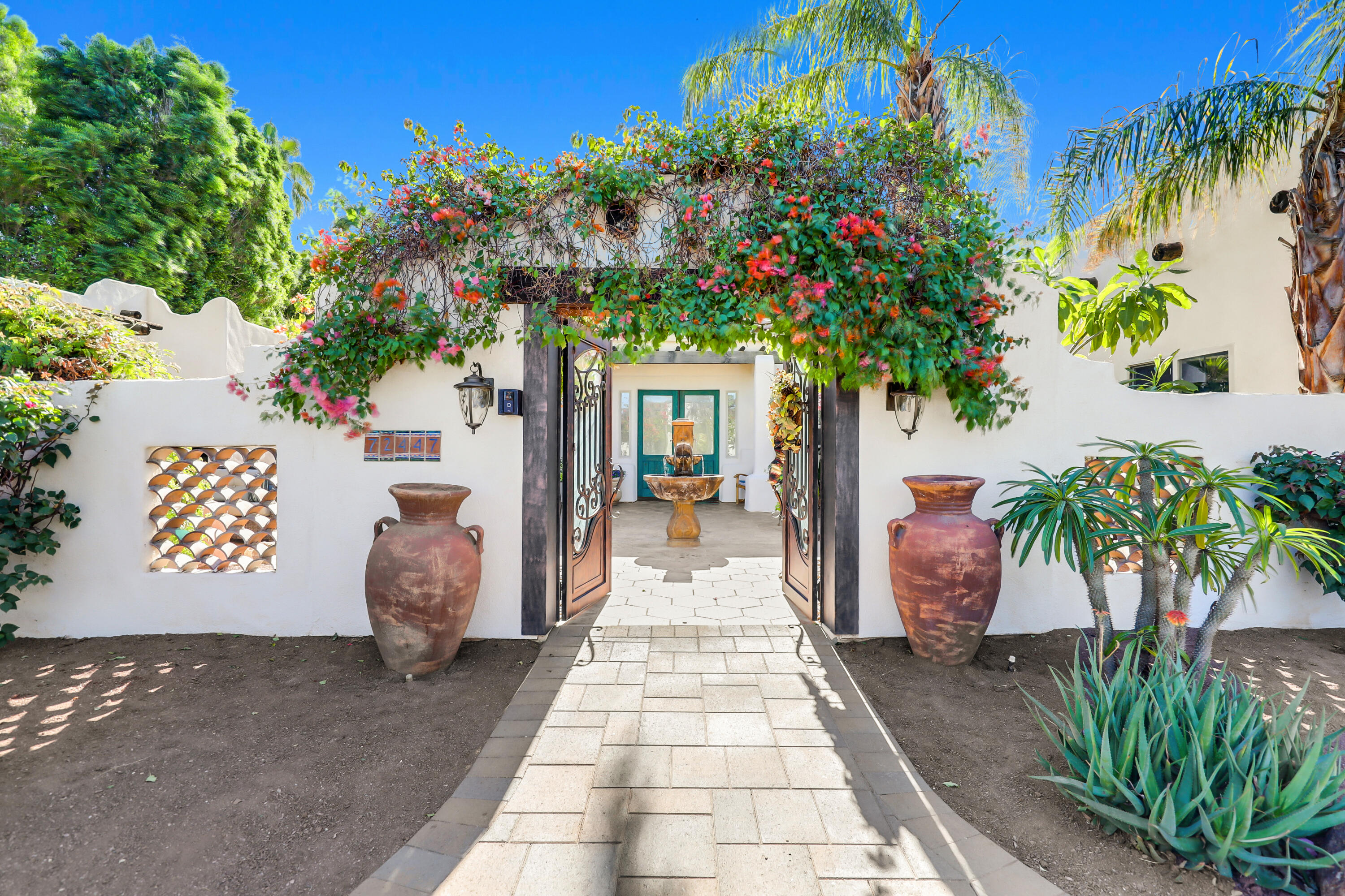 72447 Magnesia Falls Drive Rancho Mirage, CA 92270 - Photo 1 of 50 a front view of a house with a potted plant