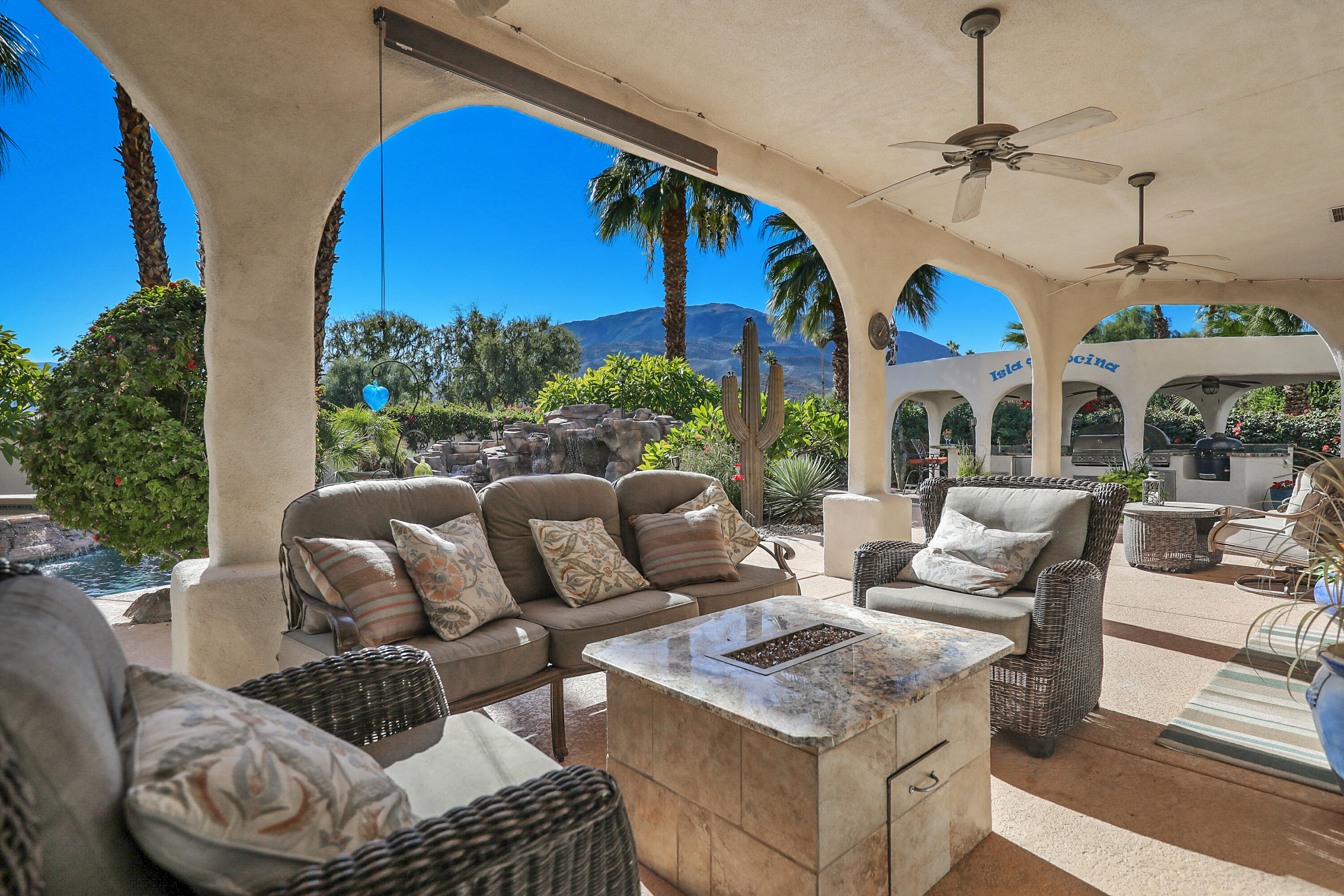 72447 Magnesia Falls Drive Rancho Mirage, CA 92270 - Photo 36 of 50 a living room with furniture a fireplace and a chandelier