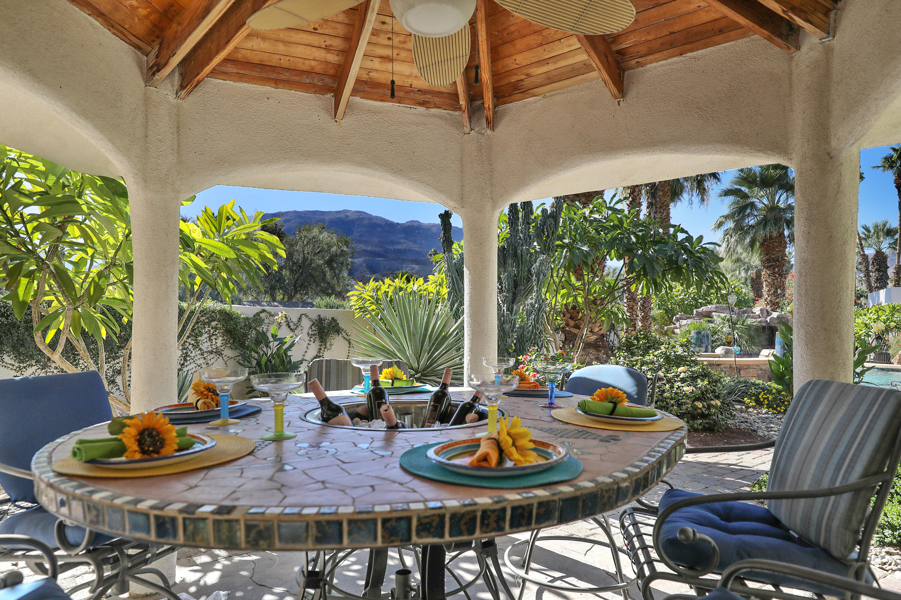 72447 Magnesia Falls Drive Rancho Mirage, CA 92270 - Photo 40 of 50 a view of a patio with table and chairs potted plants and floor to ceiling window