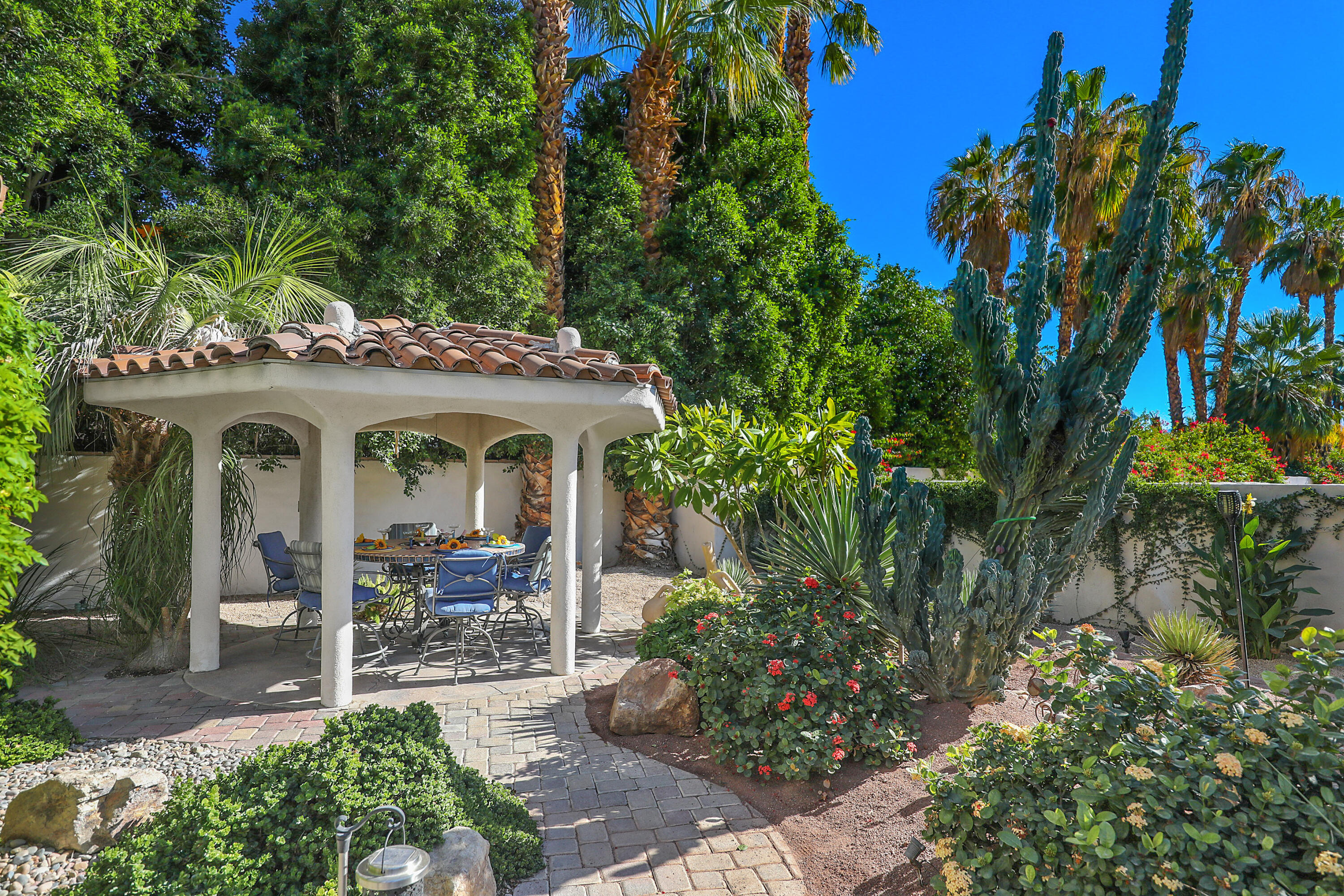 72447 Magnesia Falls Drive Rancho Mirage, CA 92270 - Photo 43 of 50 a view of a patio with table and chairs potted plants and floor to ceiling window