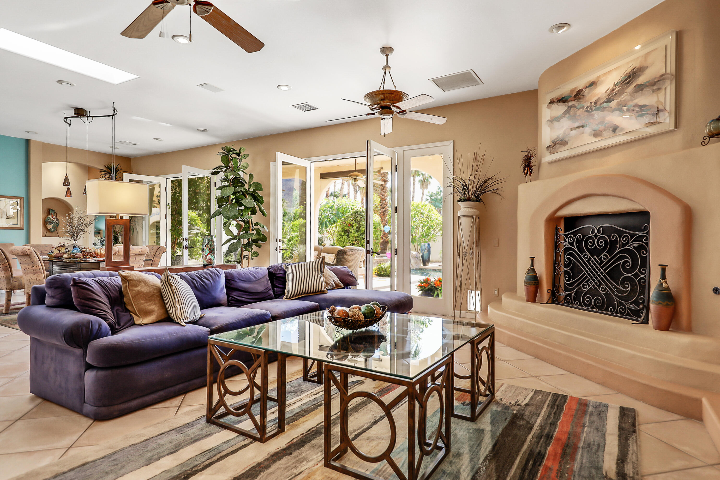 72447 Magnesia Falls Drive Rancho Mirage, CA 92270 - Photo 9 of 50 a living room with furniture a fireplace and a large window with wooden floor