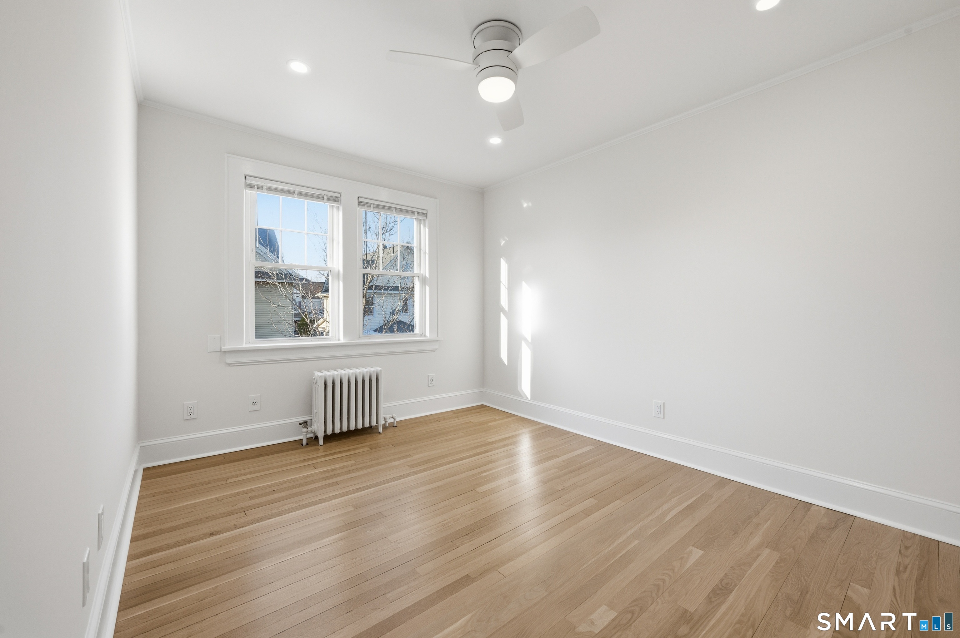 44 Lorraine Terrace, Unit 2 Bridgeport, CT 06604 - Photo 11 of 16 an empty room with wooden floor and windows