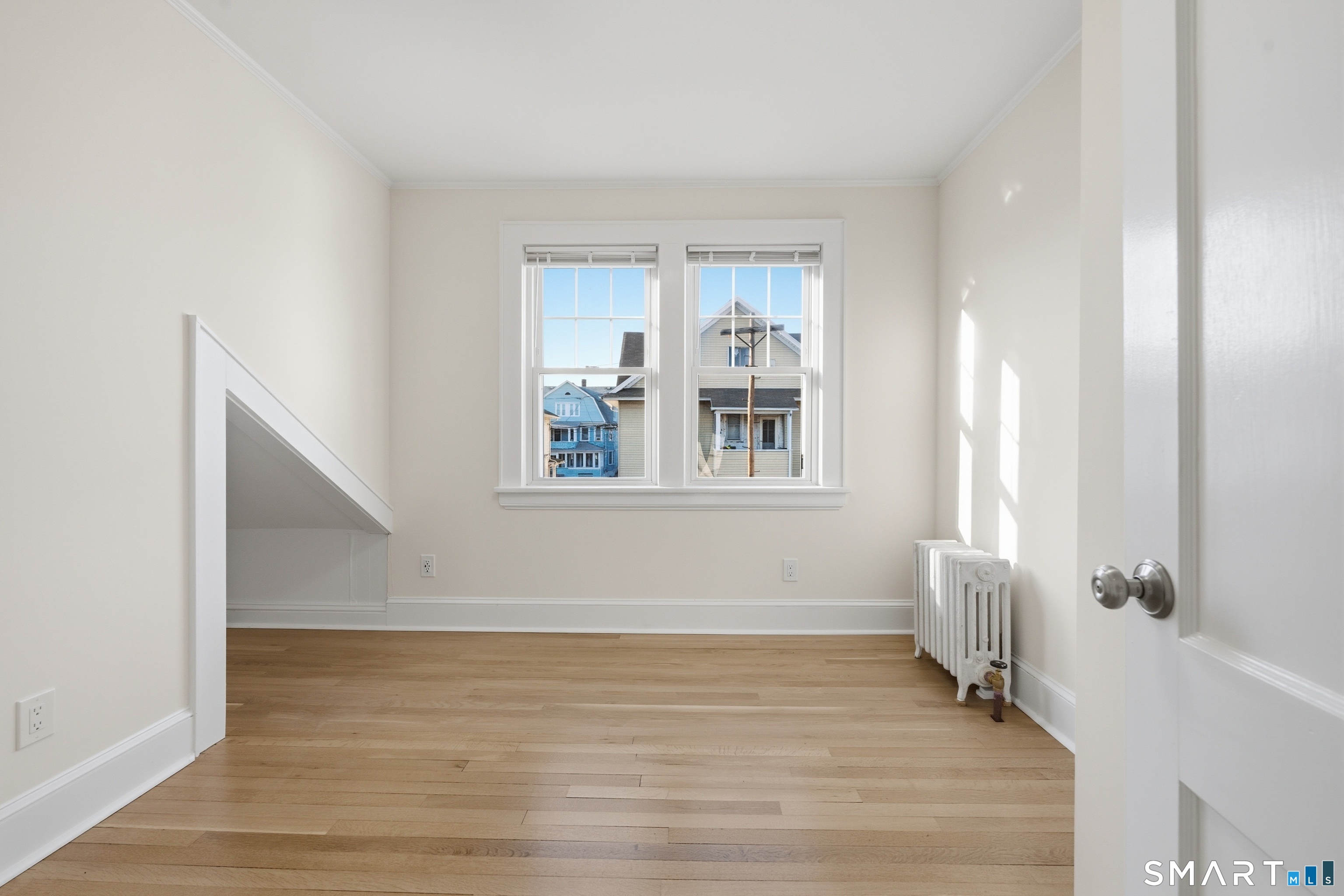 44 Lorraine Terrace, Unit 2 Bridgeport, CT 06604 - Photo 14 of 16 a view of an empty room with wooden floor and a window