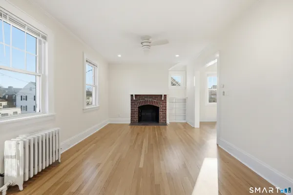 wooden floor fireplace and windows in an empty room