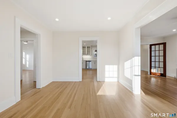 a view of a big room with wooden floor and windows
