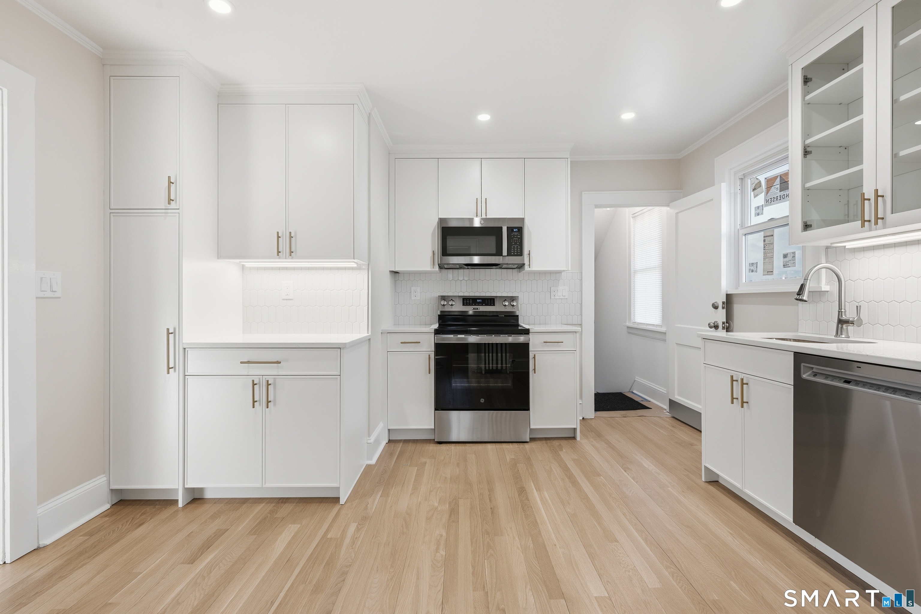 44 Lorraine Terrace, Unit 2 Bridgeport, CT 06604 - Photo 5 of 16 a kitchen with white cabinets and appliances