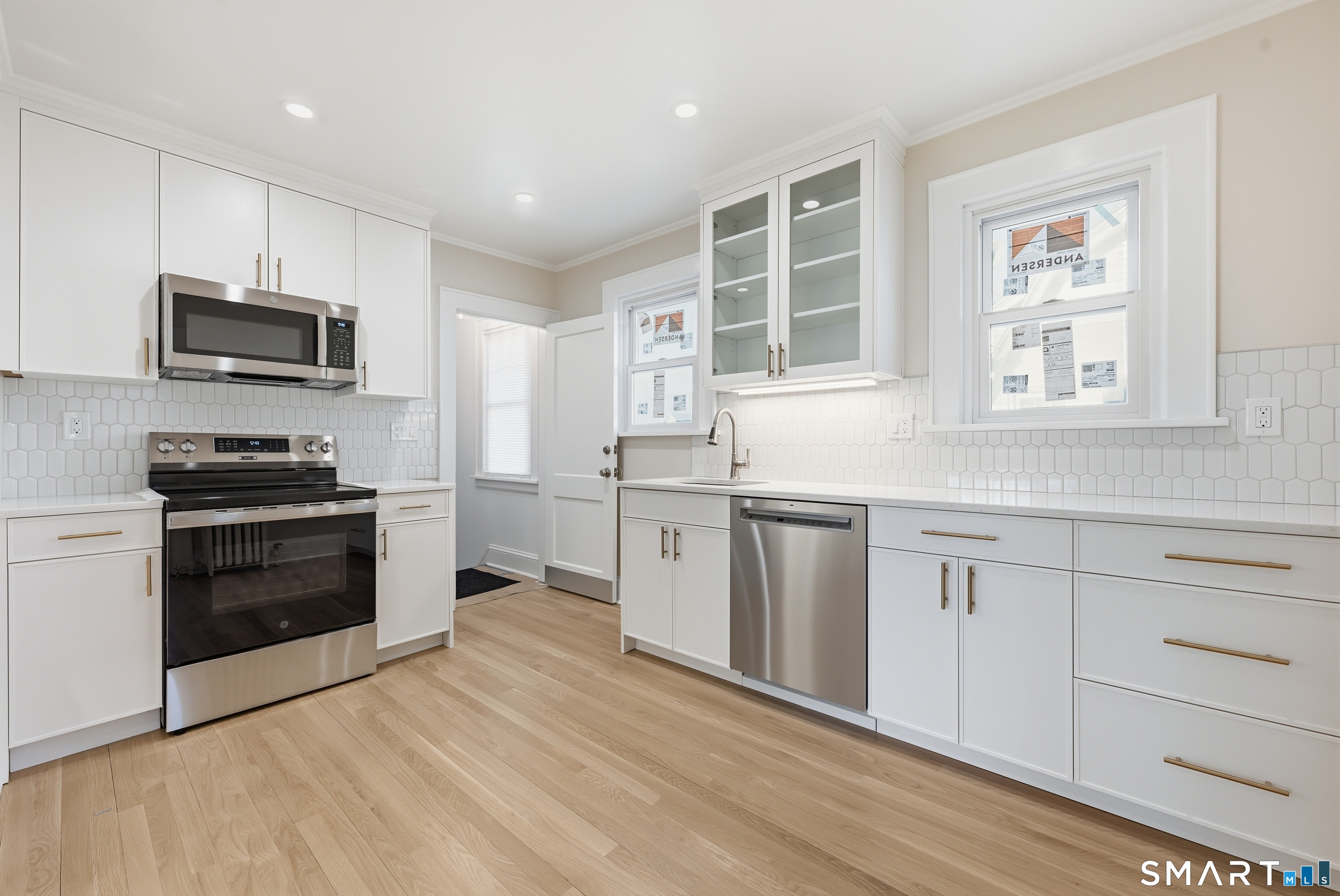 44 Lorraine Terrace, Unit 2 Bridgeport, CT 06604 - Photo 6 of 16 a kitchen with white cabinets appliances and sink
