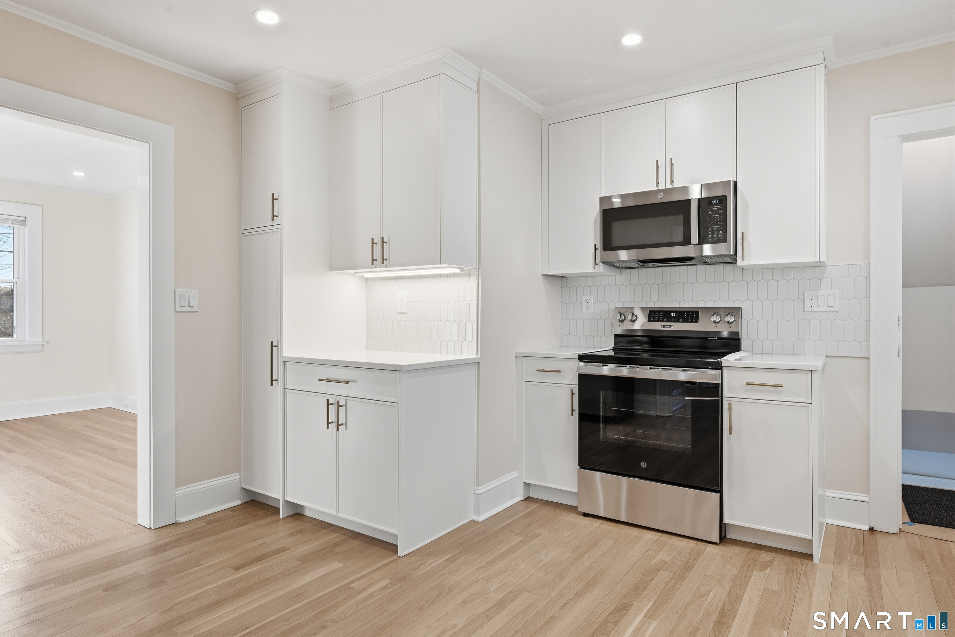 44 Lorraine Terrace, Unit 2 Bridgeport, CT 06604 - Photo 9 of 16 a kitchen with stainless steel appliances white cabinets and a stove