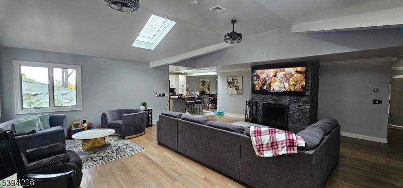 11 Surrey Place, Unit 1 Hawthorne, NJ 07506 - Photo 7 of 13 a living room with furniture a fireplace and a flat screen tv