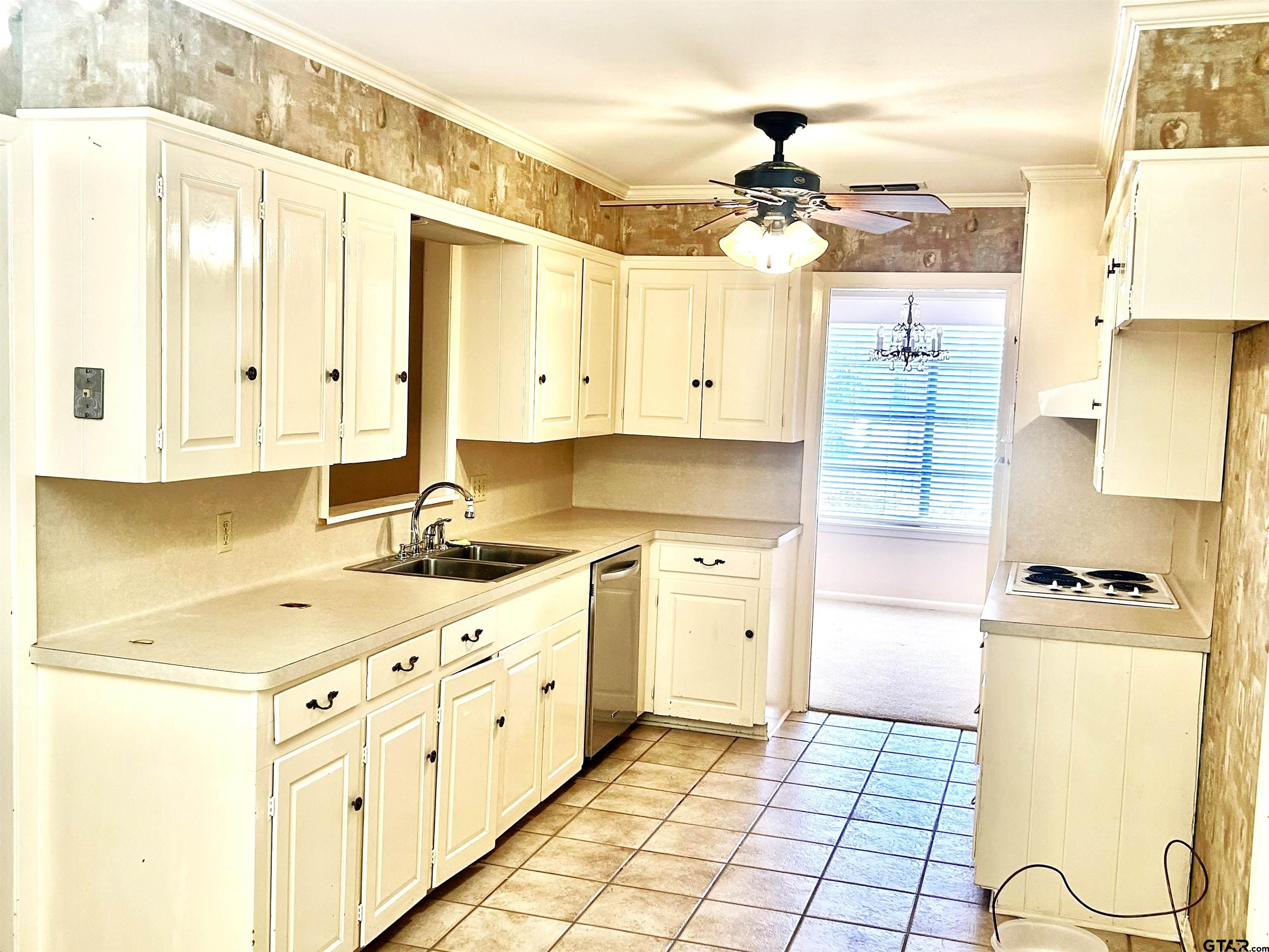 3713 Colgate Avenue Tyler, TX 75701 - Photo 3 of 13 a kitchen with cabinets appliances and a ceiling fan