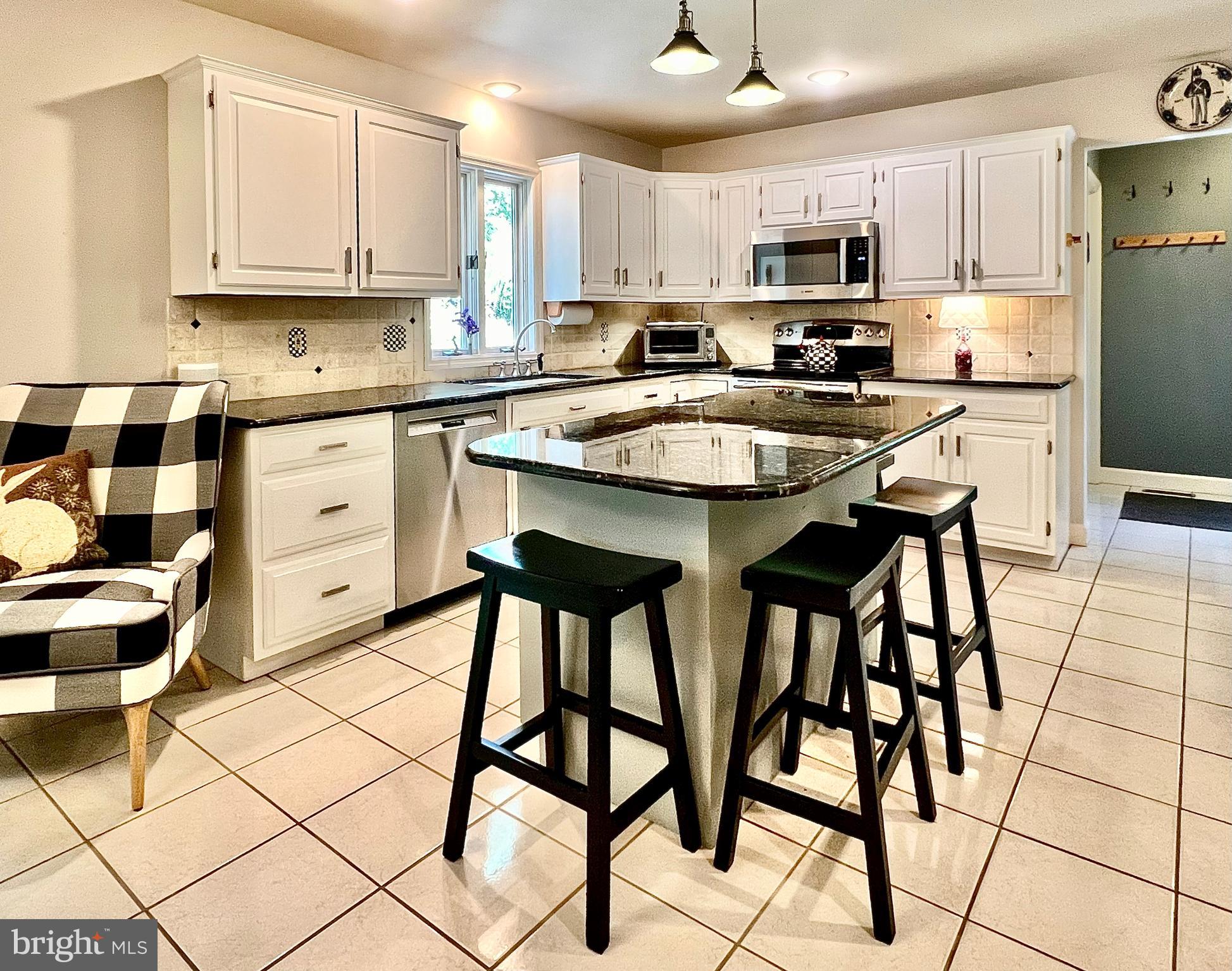 3 Royal Court Reading, PA 19607 - Photo 12 of 39 a kitchen with stainless steel appliances kitchen island granite countertop a table chairs microwave and sink