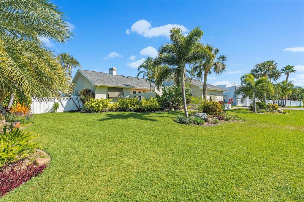 725 Monte Cristo Boulevard Tierra Verde, FL 33715 - Photo 3 of 63 a view of a house with a big yard and palm trees