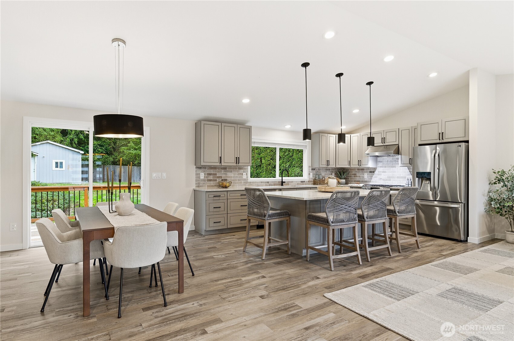 18217 152nd Avenue Southeast Renton, WA 98058 - Photo 4 of 30 a dining room with stainless steel appliances kitchen island granite countertop a table chairs and a view of living room