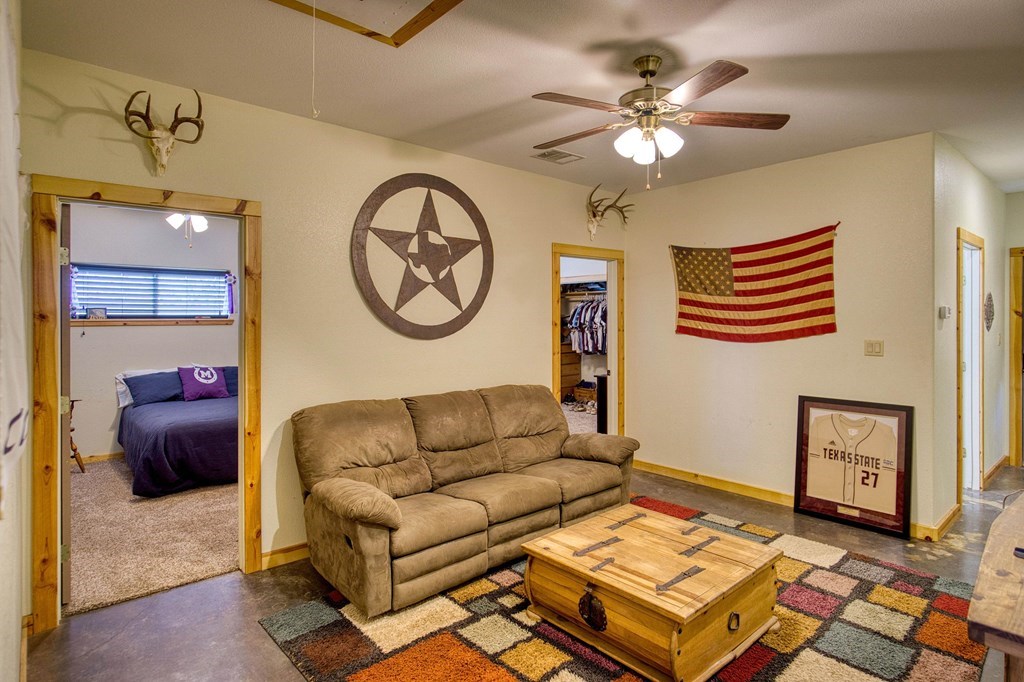 6446 Blackjack Road Fredonia, TX 76842 - Photo 28 of 48 a living room with couches a fireplace and a chandelier