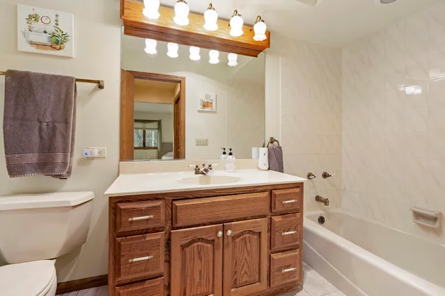 a bathroom with a sink a toilet a mirror and shower