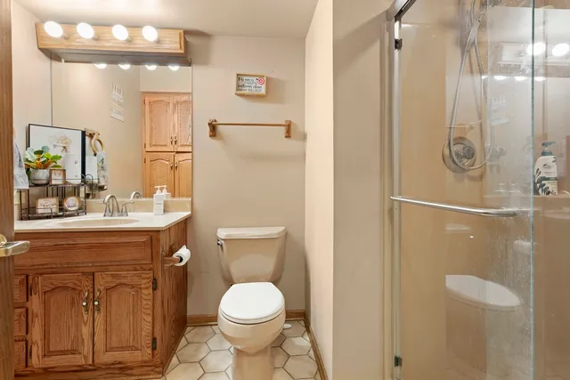a bathroom with a granite countertop sink toilet and shower
