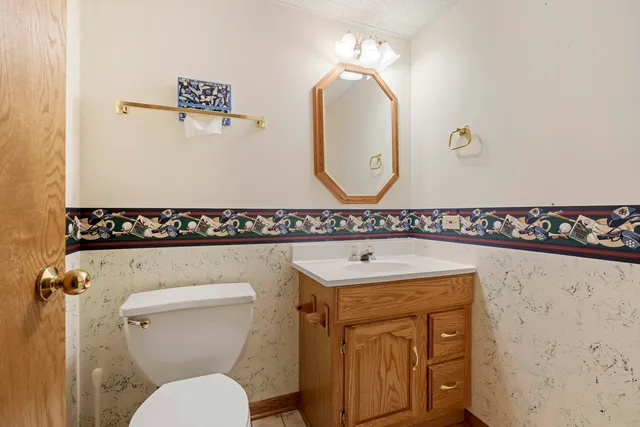 a bathroom with a toilet a sink and a mirror