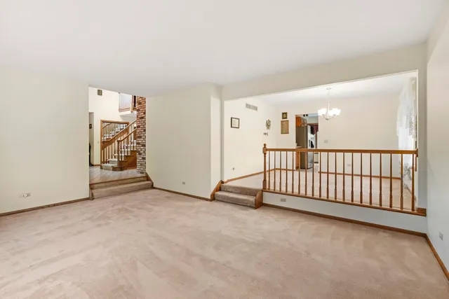 a view of a livingroom with entryway stairs and white walls