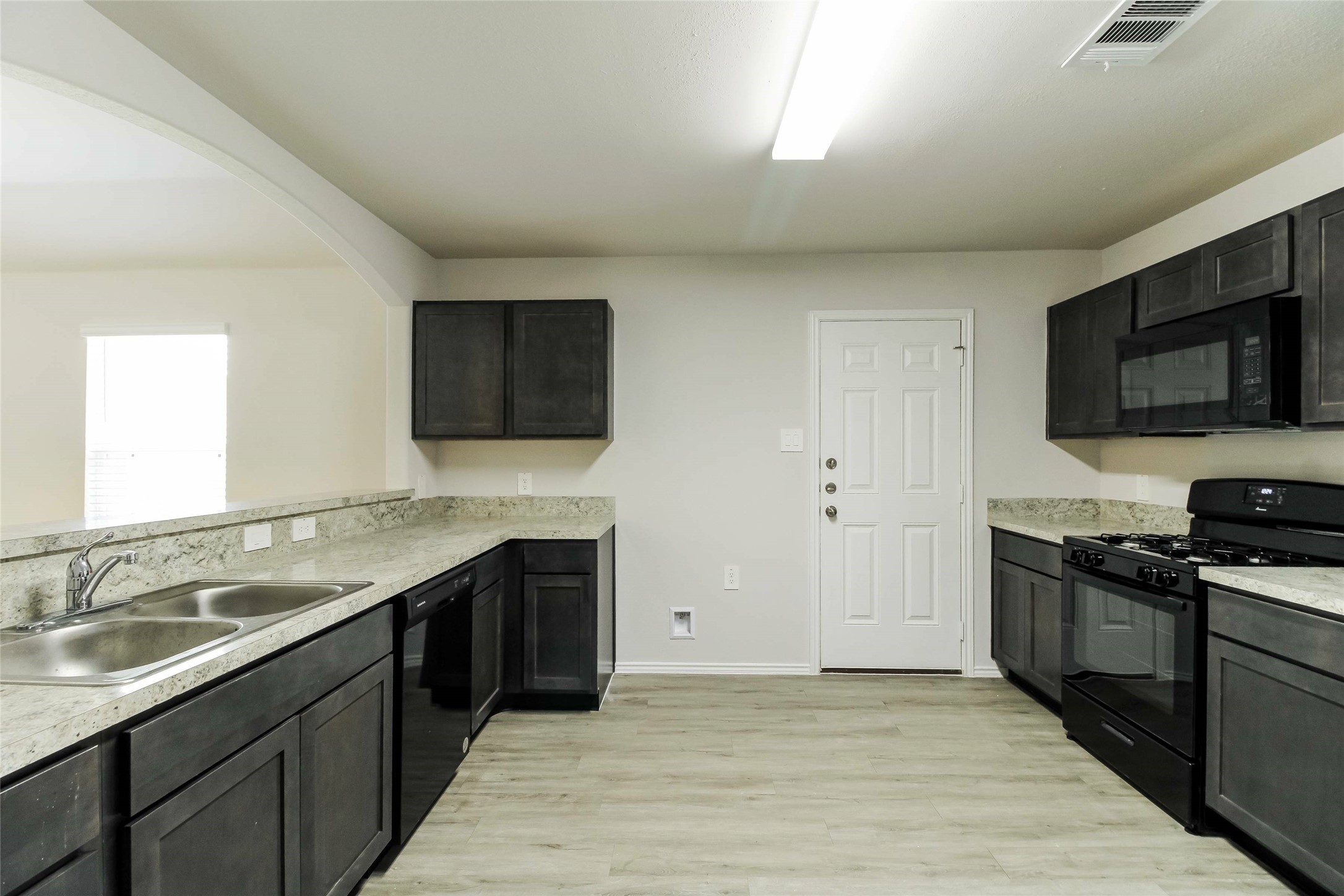 2528 Shad Drive Conroe, TX 77384 - Photo 3 of 16 a kitchen with stainless steel appliances granite countertop a sink and a stove top oven with wooden floor