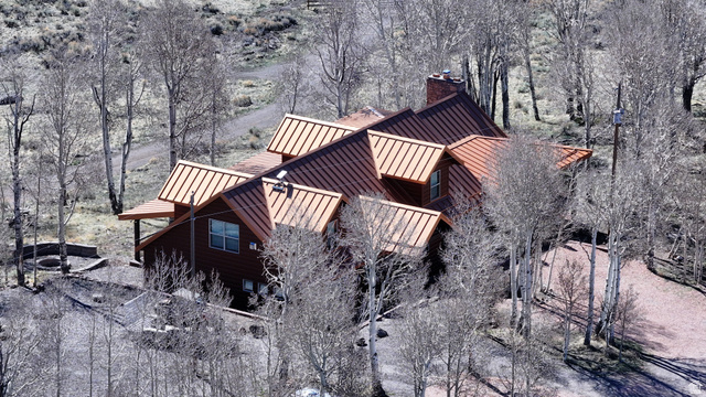 2031 South Quakie Road Koosharem, UT 84744 - Photo 1 of 33 Wood-sided exterior with a multi-pitched metal roof and a stone chimney