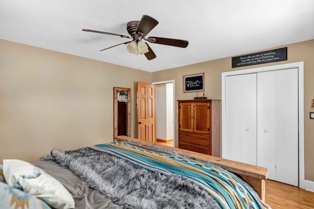 a bedroom with a bed and wooden floor