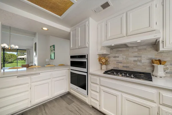 a kitchen with white cabinets and appliances