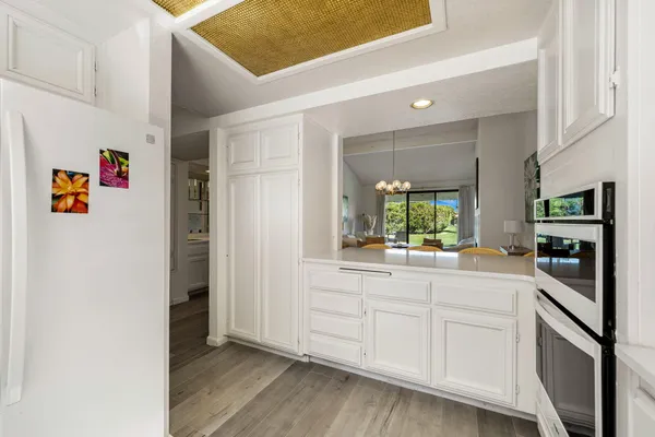 a hallway with white cabinets and window