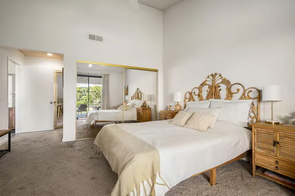 a bedroom with a large bed and a chandelier