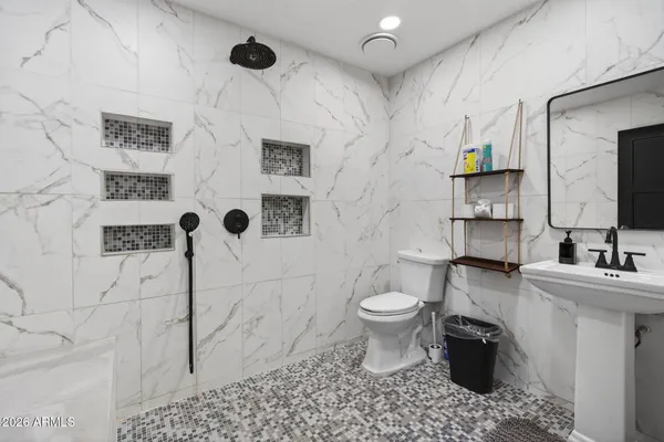 a bathroom with a toilet sink and mirror