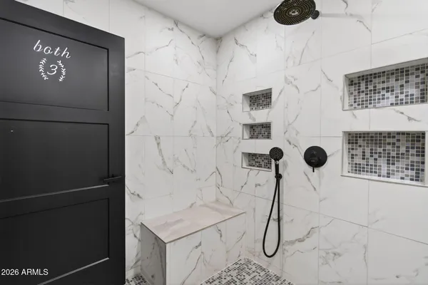 a bathroom with a shower and mirror