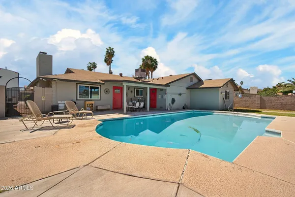 a view of a house with swimming pool and sitting area