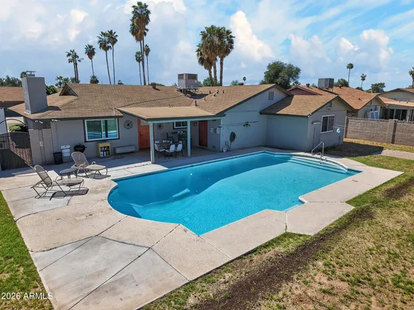 a view of a house with pool and chairs