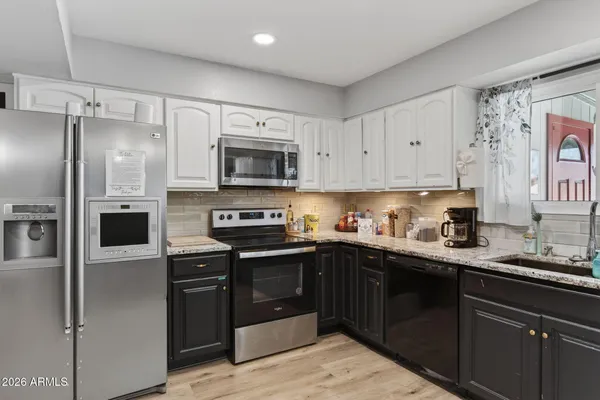 a kitchen with kitchen island granite countertop a sink stainless steel appliances and cabinets