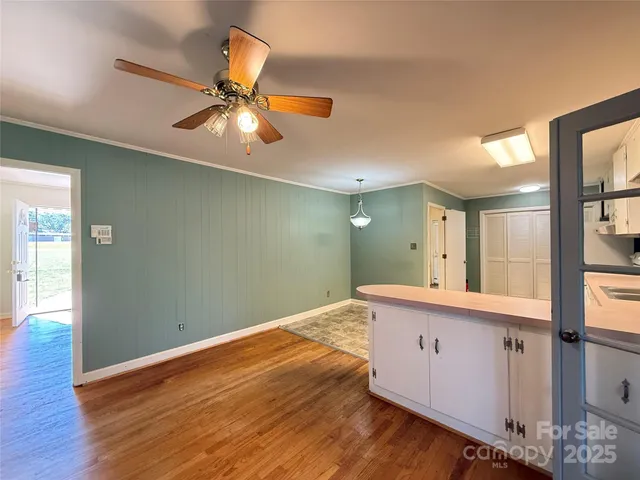 a view of an empty room and window and wooden floor