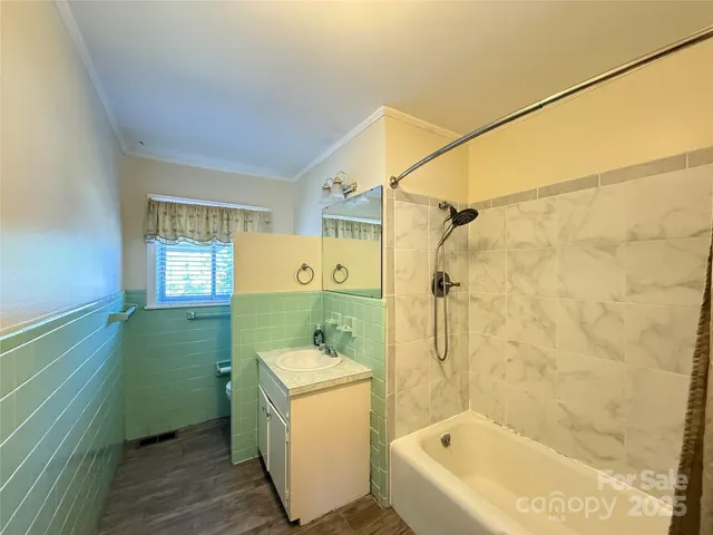 a bathroom with a sink a mirror toilet and bathtub