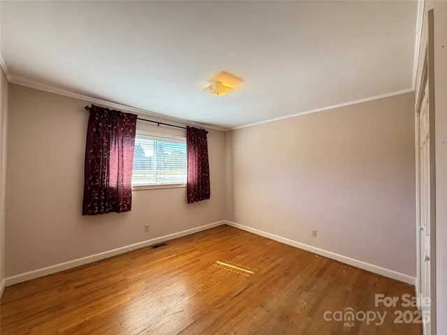 an empty room with windows and cabinet