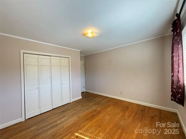 an empty room with wooden floor and windows in a room