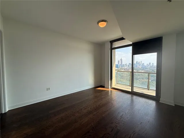 an empty room with wooden floor and glass door