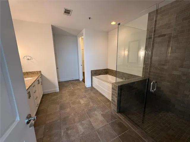 a bathroom with granite countertop double vanity and a mirror