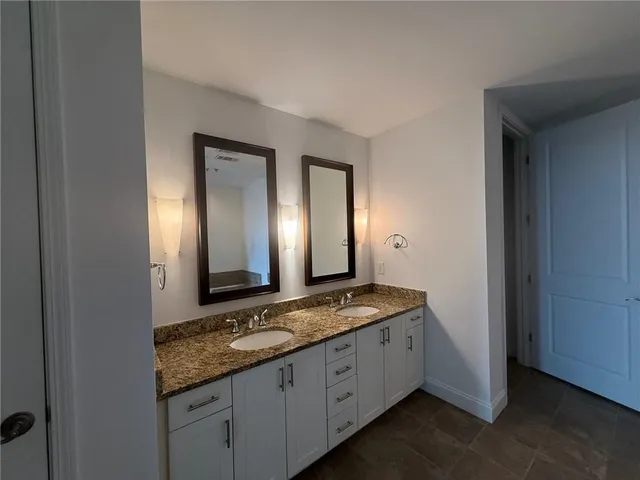 a bathroom with a granite countertop sink mirror and shower