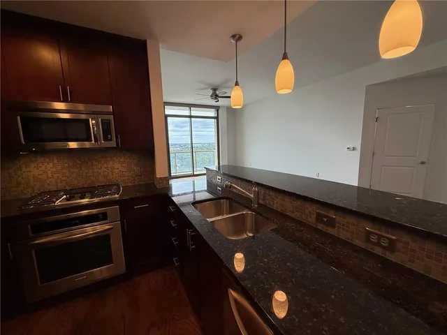 a kitchen with stainless steel appliances granite countertop a sink a oven and a granite counter top