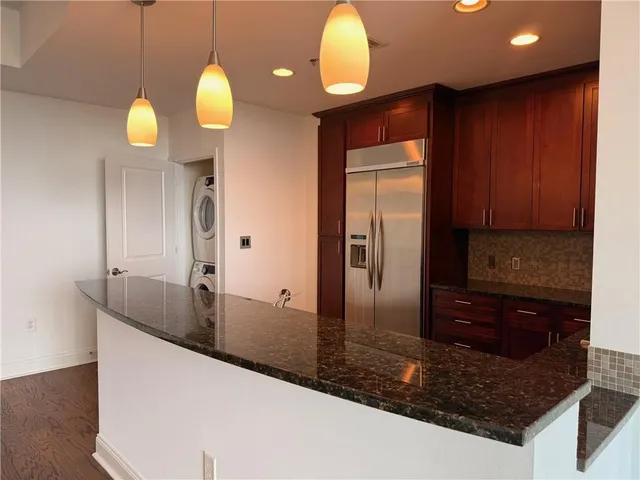 a view of a kitchen with a sink and dishwasher with wooden floor