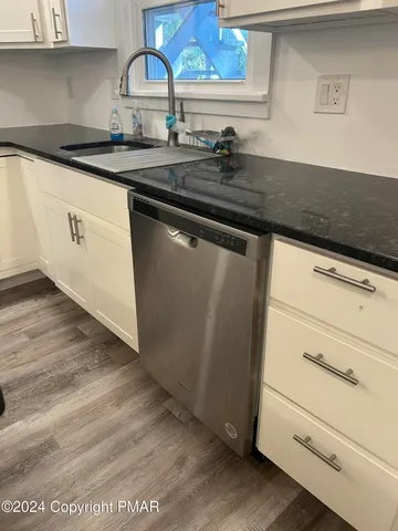 a kitchen with granite countertop white cabinets and a stove