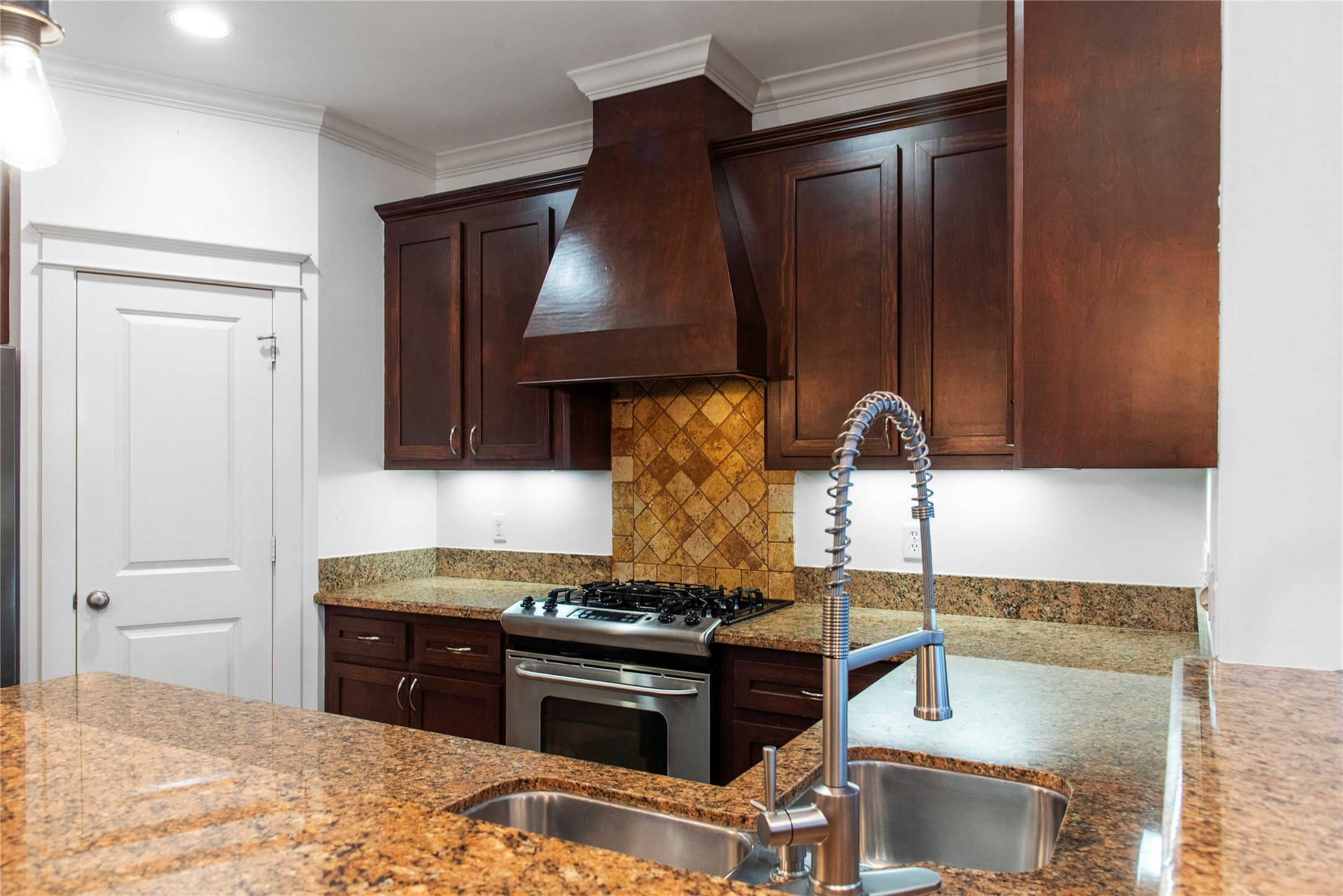 1505 Prince Street Houston, TX 77008 - Photo 14 of 39 Handsome, rich-looking kitchen featuring gleaming counters, dark wood cabinetry, double sinks, and an elegant swan-neck faucet.